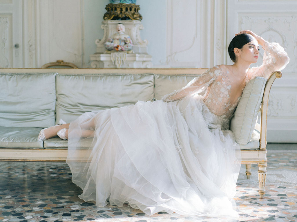 Model lounging in a designer wedding dress elegantly.