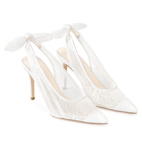 Pair of ivory lace slingback pointed-toe heels with bow ties on the back.